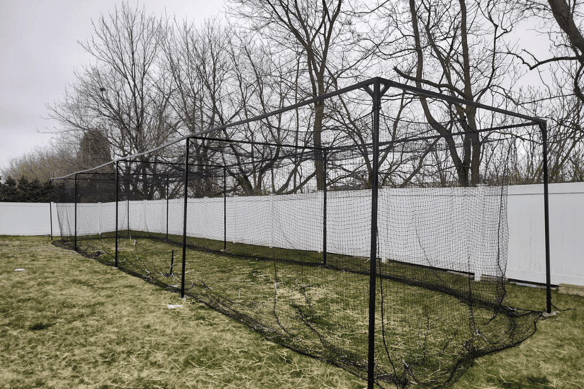 Budget backyard batting cage with portable net frame during initial setup