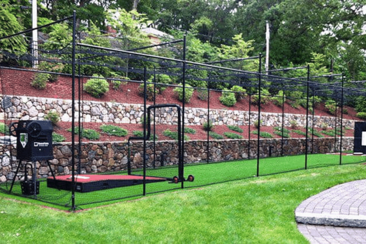 A well-equipped backyard batting cage build, with netting, frame, and turf