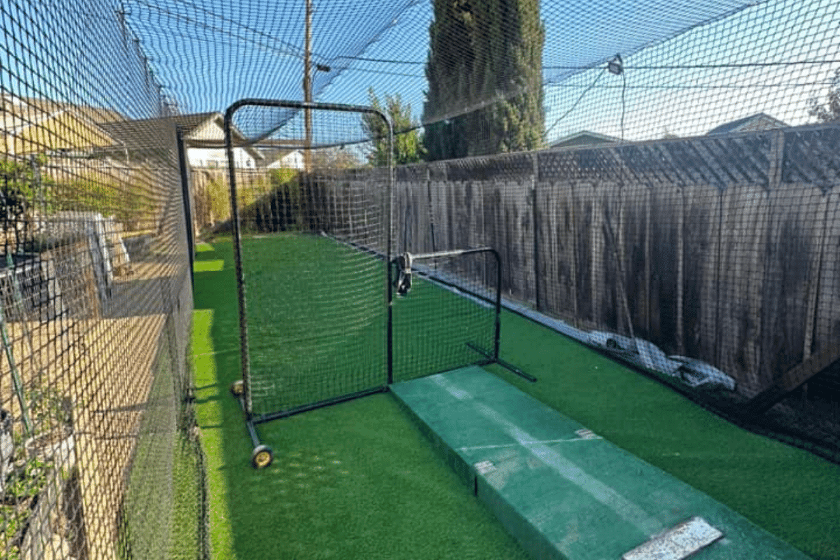 Mid-range batting cage interior with L-screen and practice mat