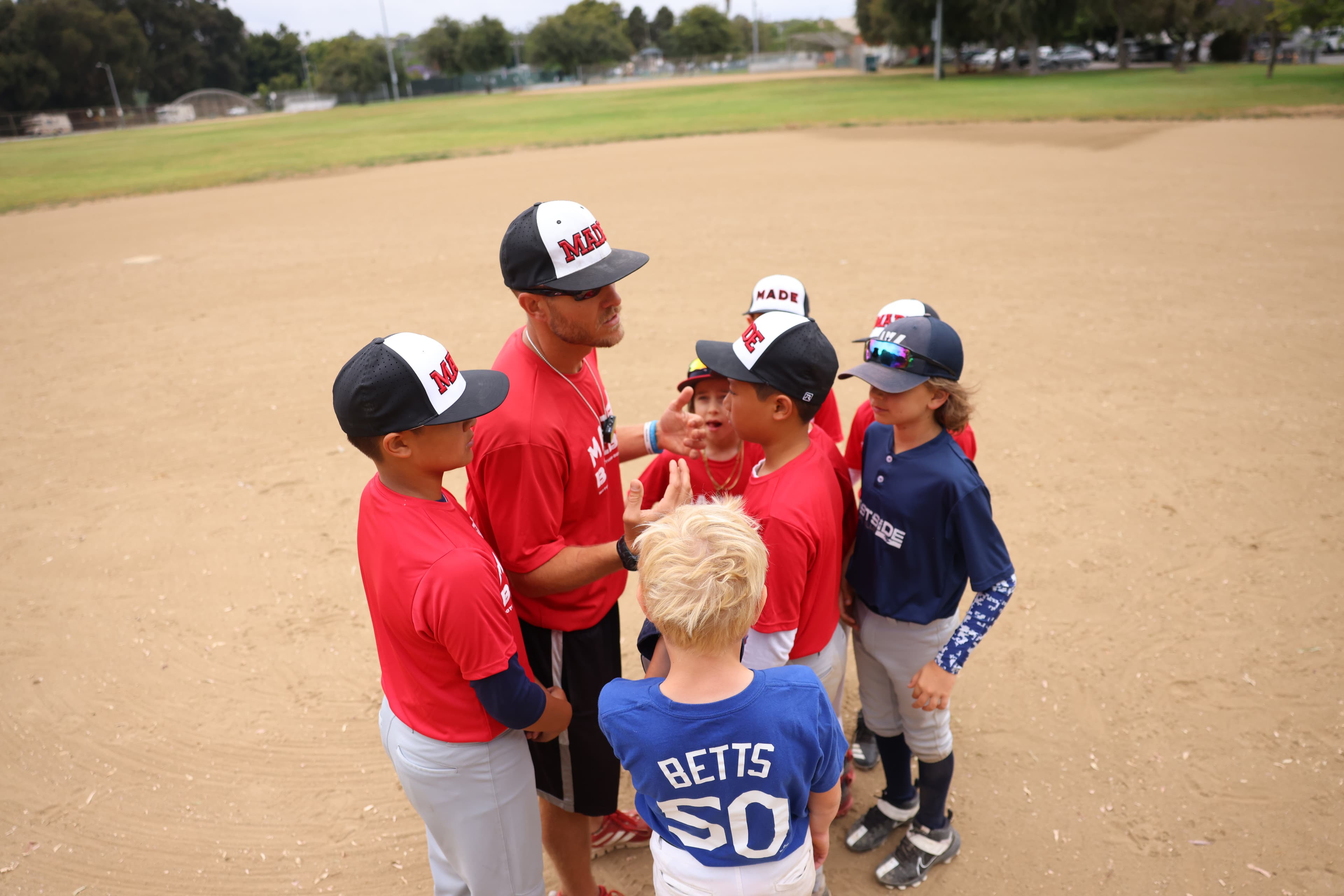 Coach huddling with a youth baseball team