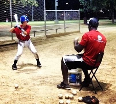 Youth travel-ball player in a maroon team jersey in his batting stance