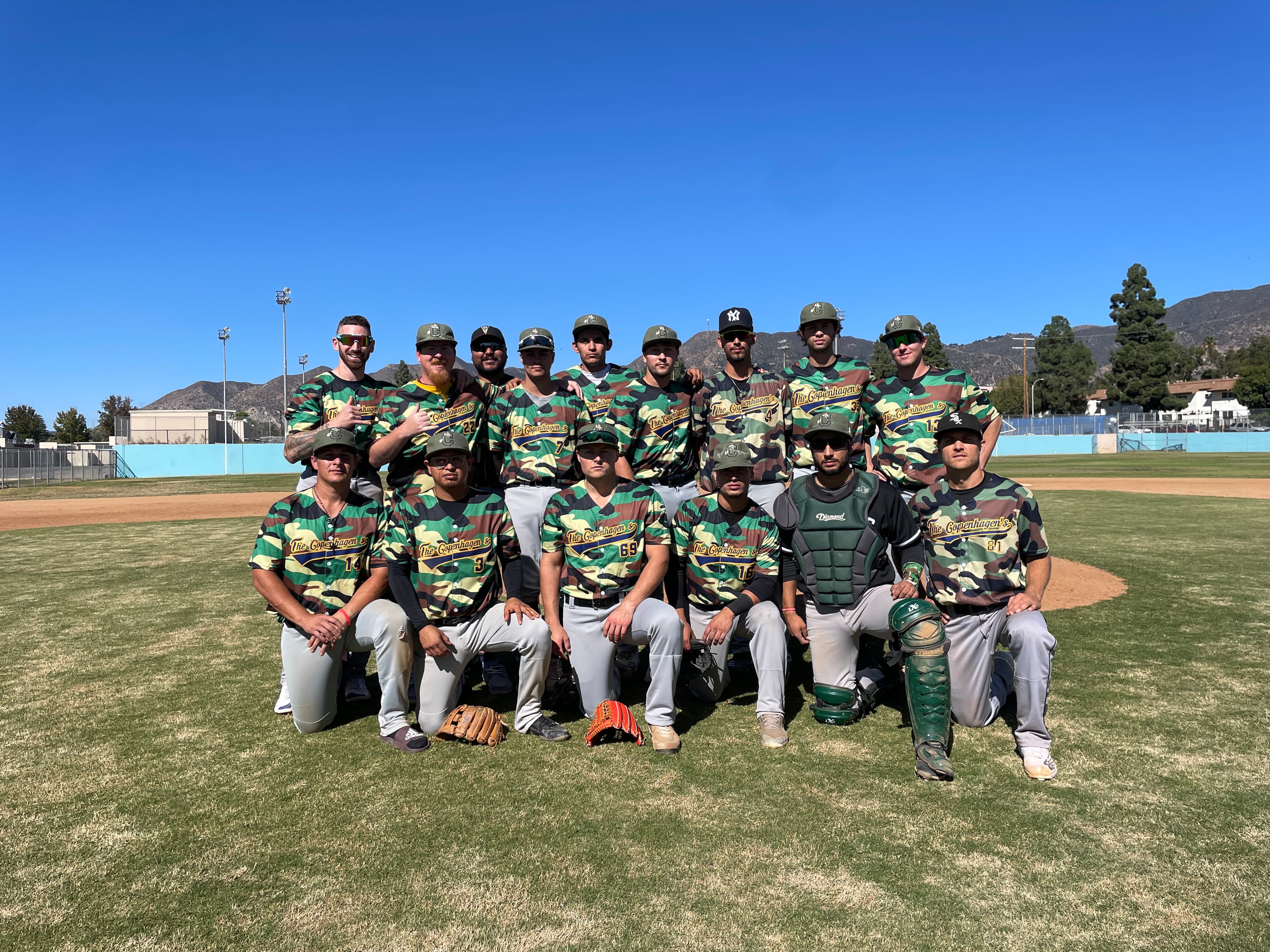 Men's league baseball team posed on the field