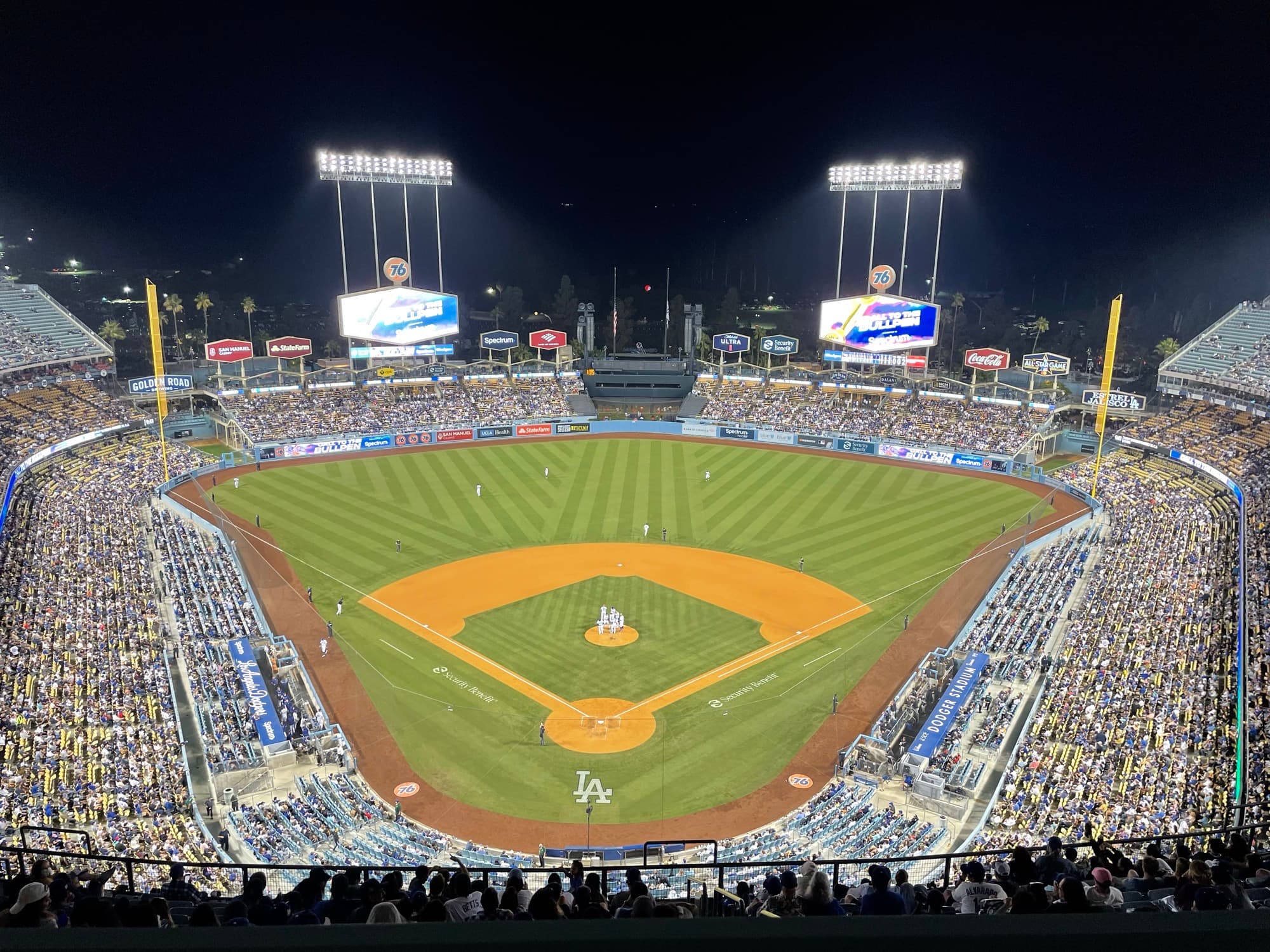 Night view of a packed Dodger Stadium from the upper deck, field lights on