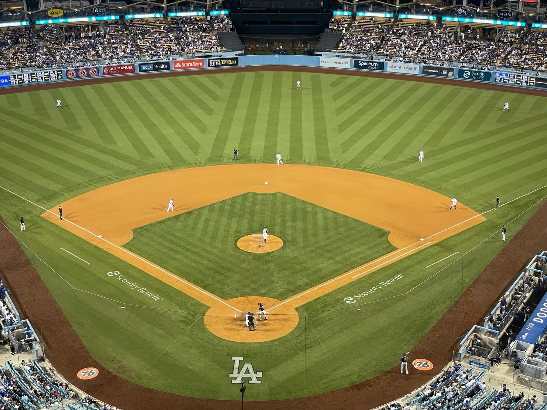 Night view of a major league infield from the upper deck, with a pitcher on the mound, a batter at the plate and fielders spread across the grass