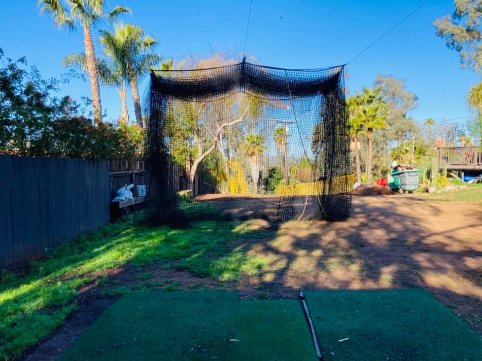 A real backyard batting cage, tree-to-tree and fully retractable