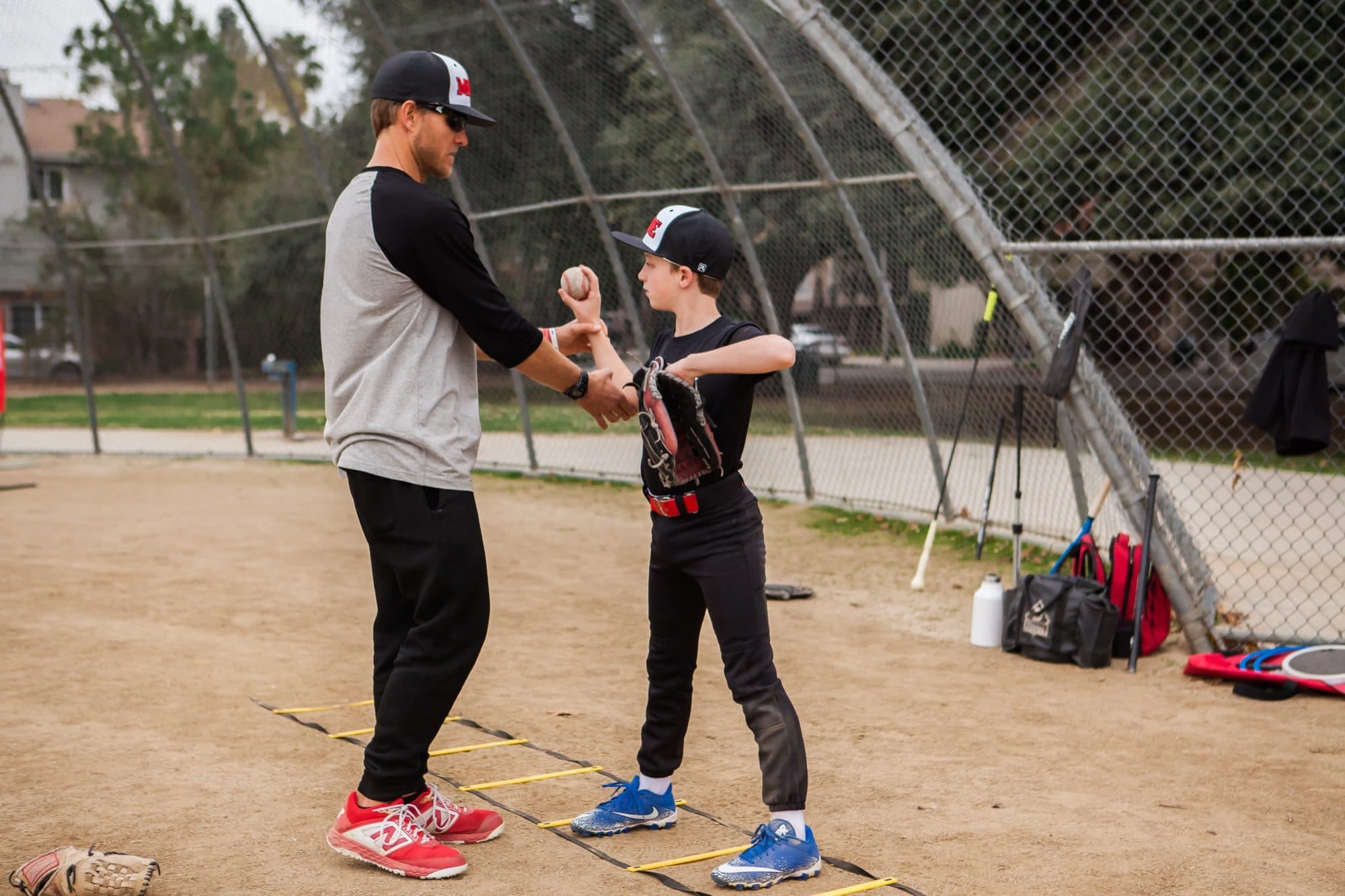 A coach setting a young hitter's hands on the bat during a lesson