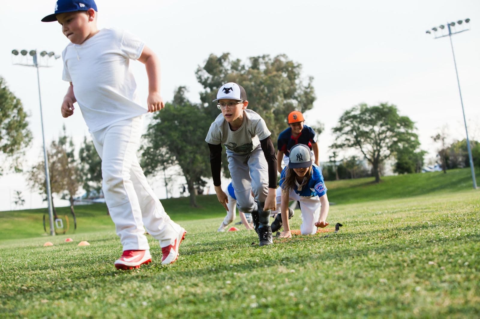 Young players racing across the grass in a bear-crawl relay