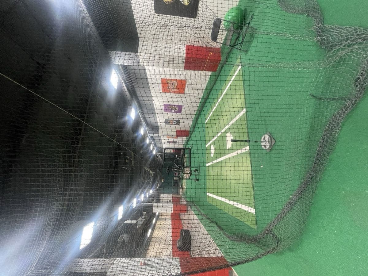 An empty indoor hitting tunnel seen through the net