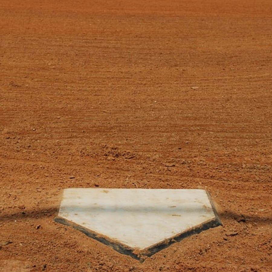 Home plate on a dirt infield, freshly chalked