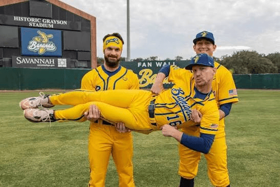 Banana Ball players in yellow uniforms posing on a baseball field