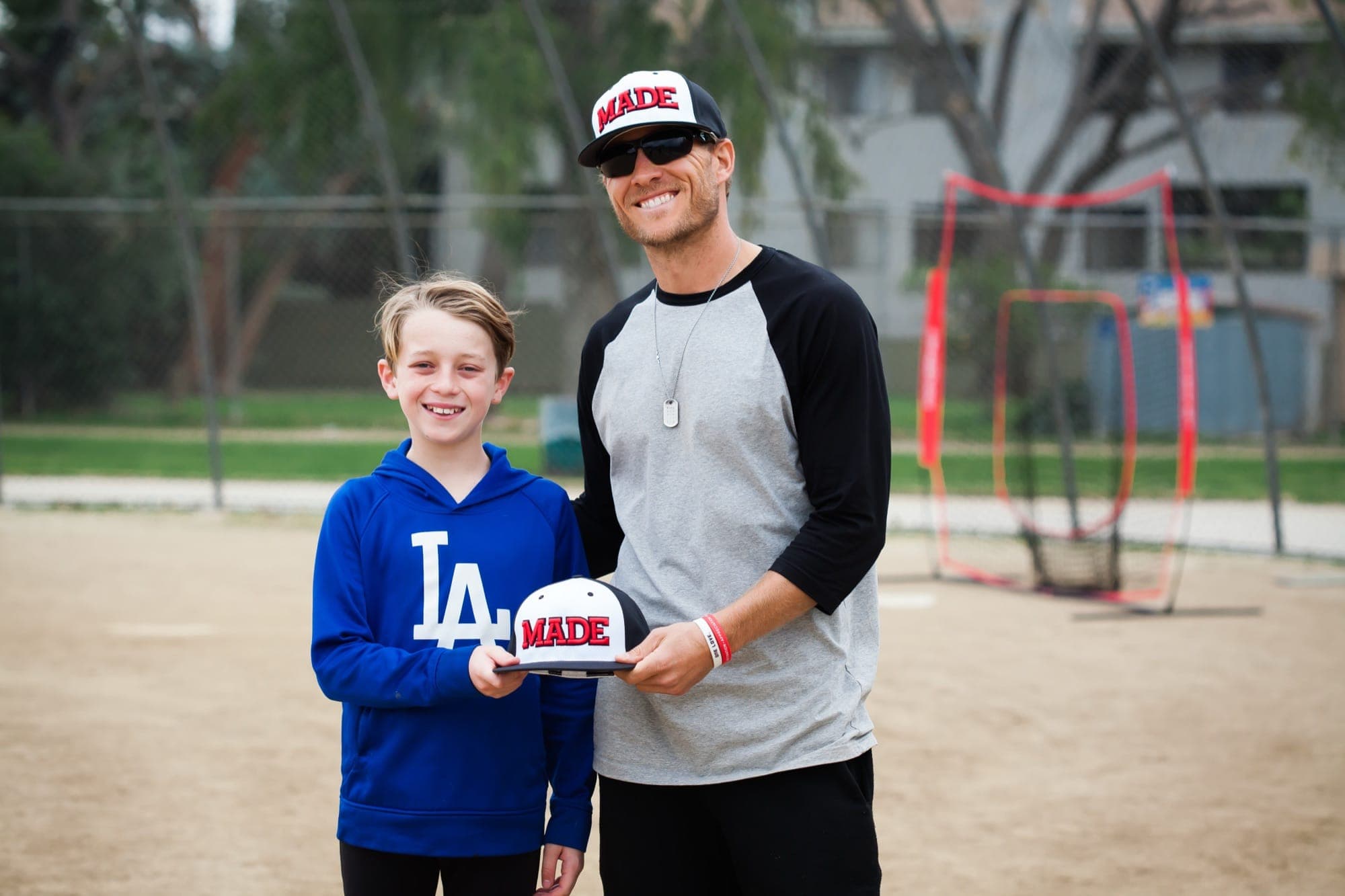 Coach Isaac with a young player holding a cap