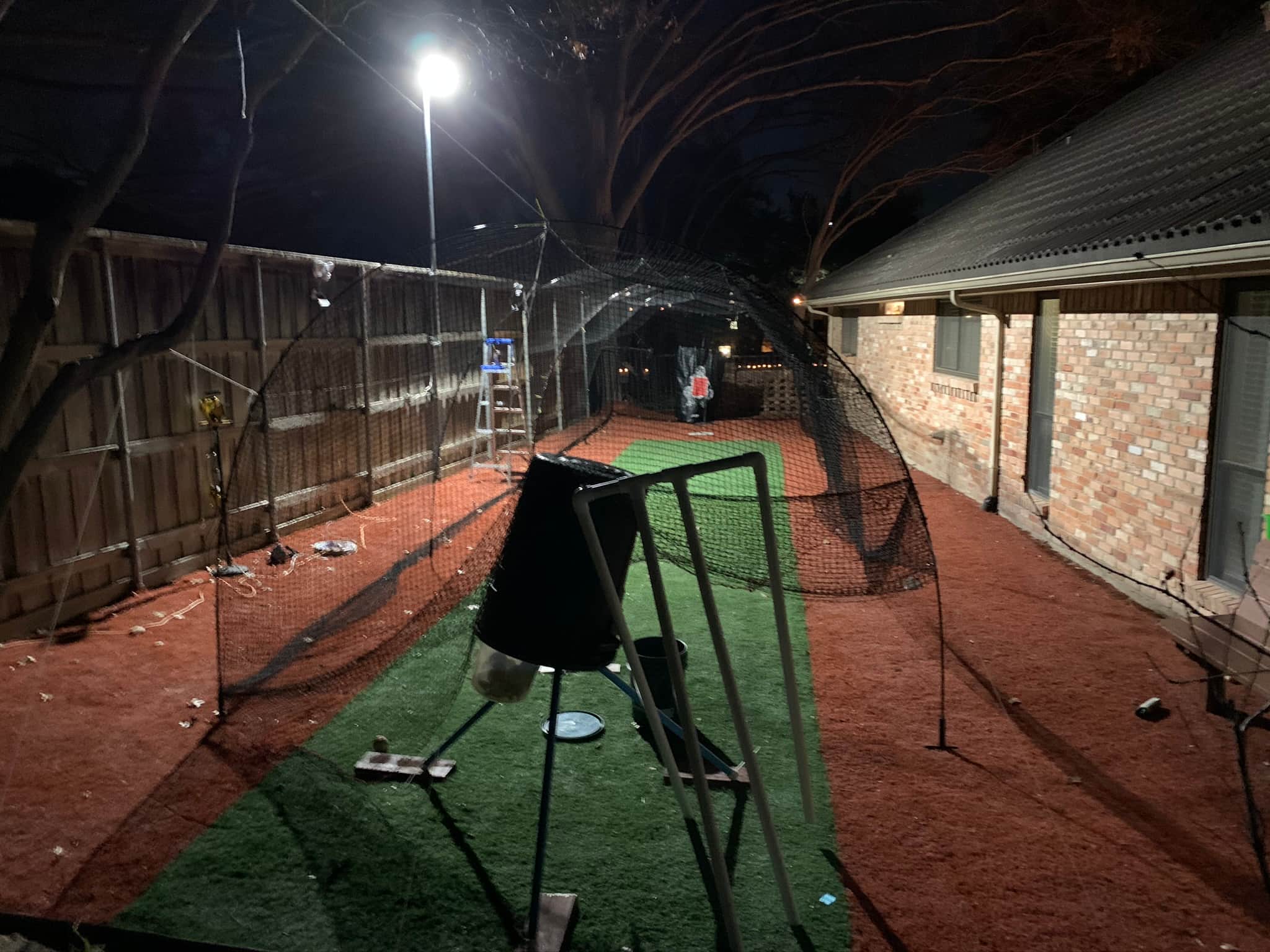 Batting cage with pitching machine and mound. Approx in Dallas, TX