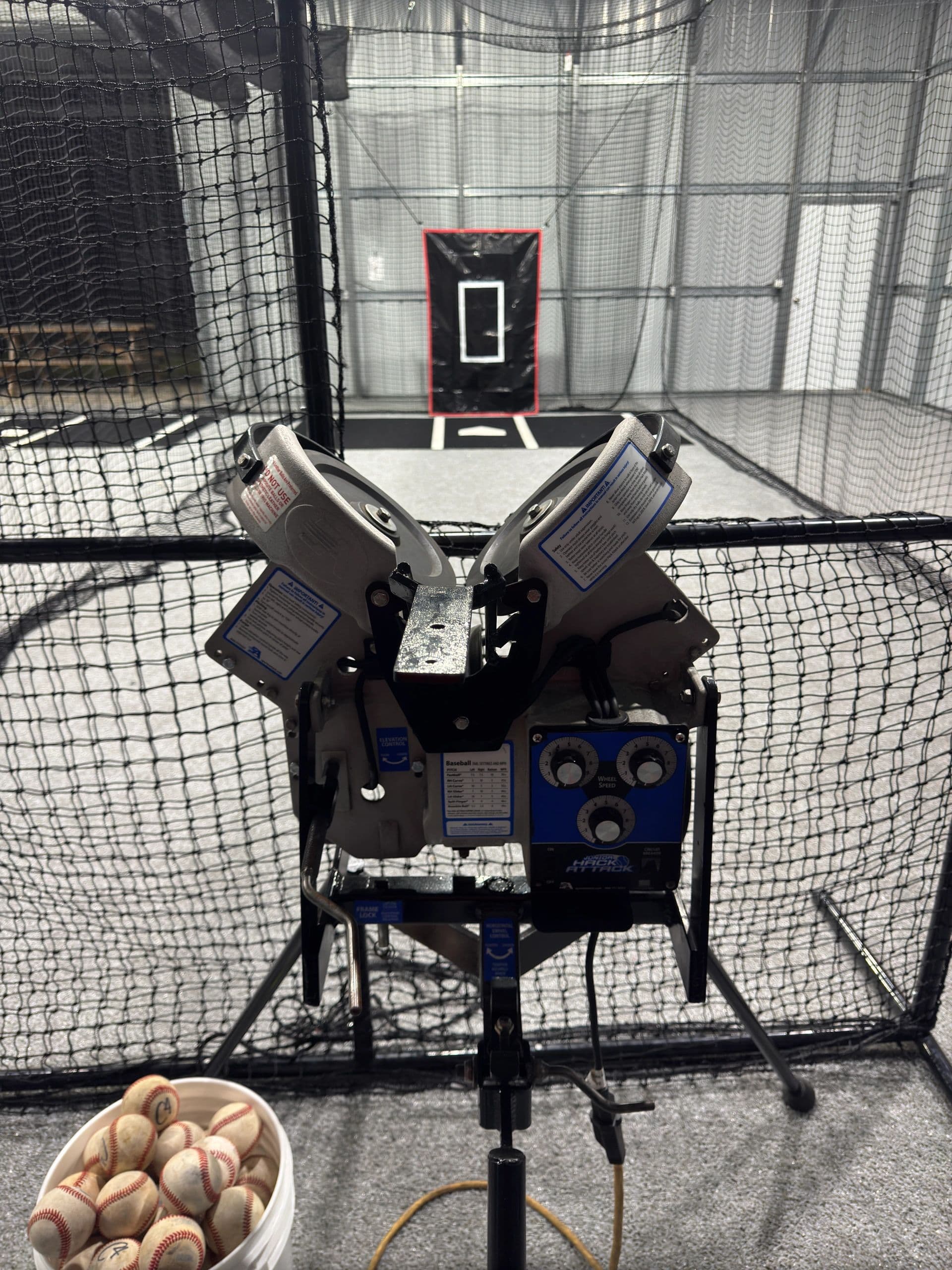 Junior Hack Attack machine set up for baseball with a bucket of balls