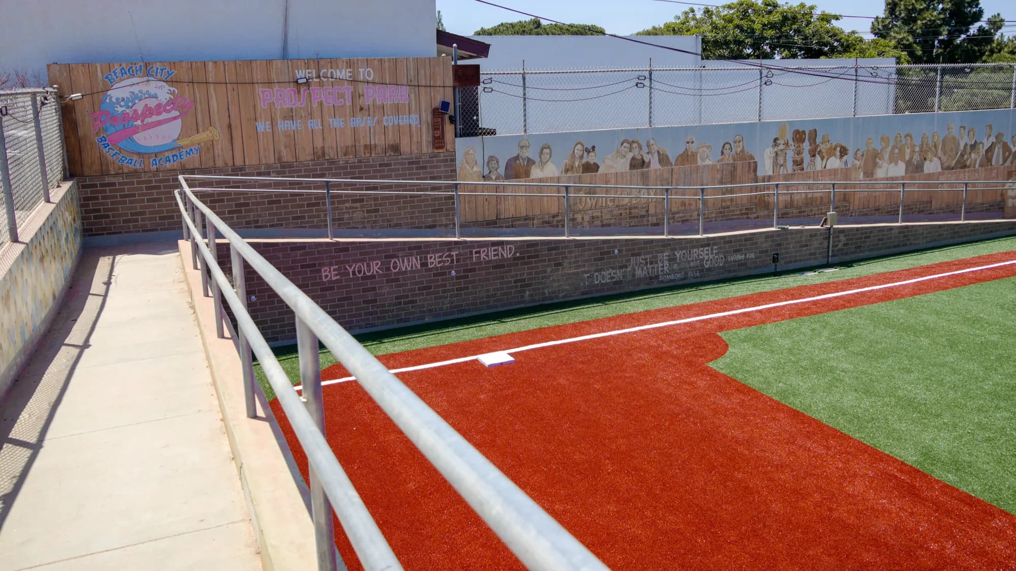 The outdoor turf field and baseline fence at Beach City Baseball Academy