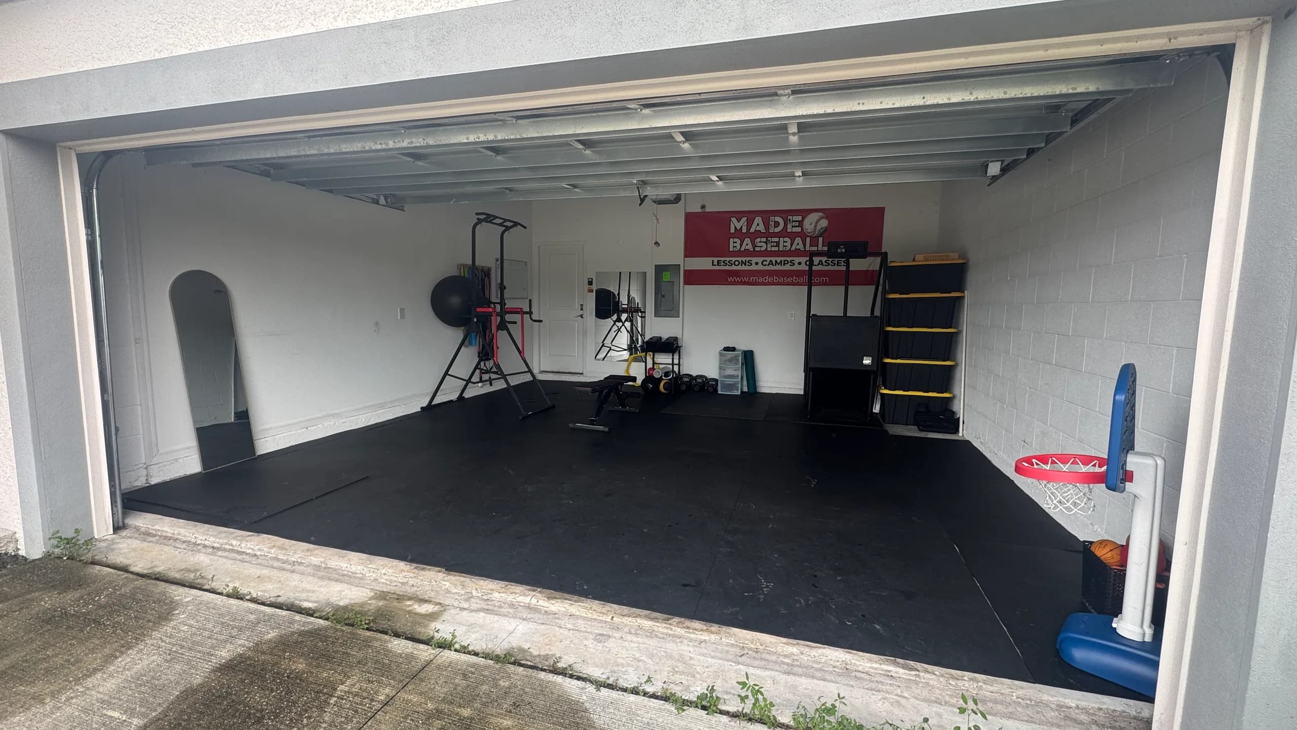 MADE Baseball garage training facility in Saint Cloud with the door open to the full bay