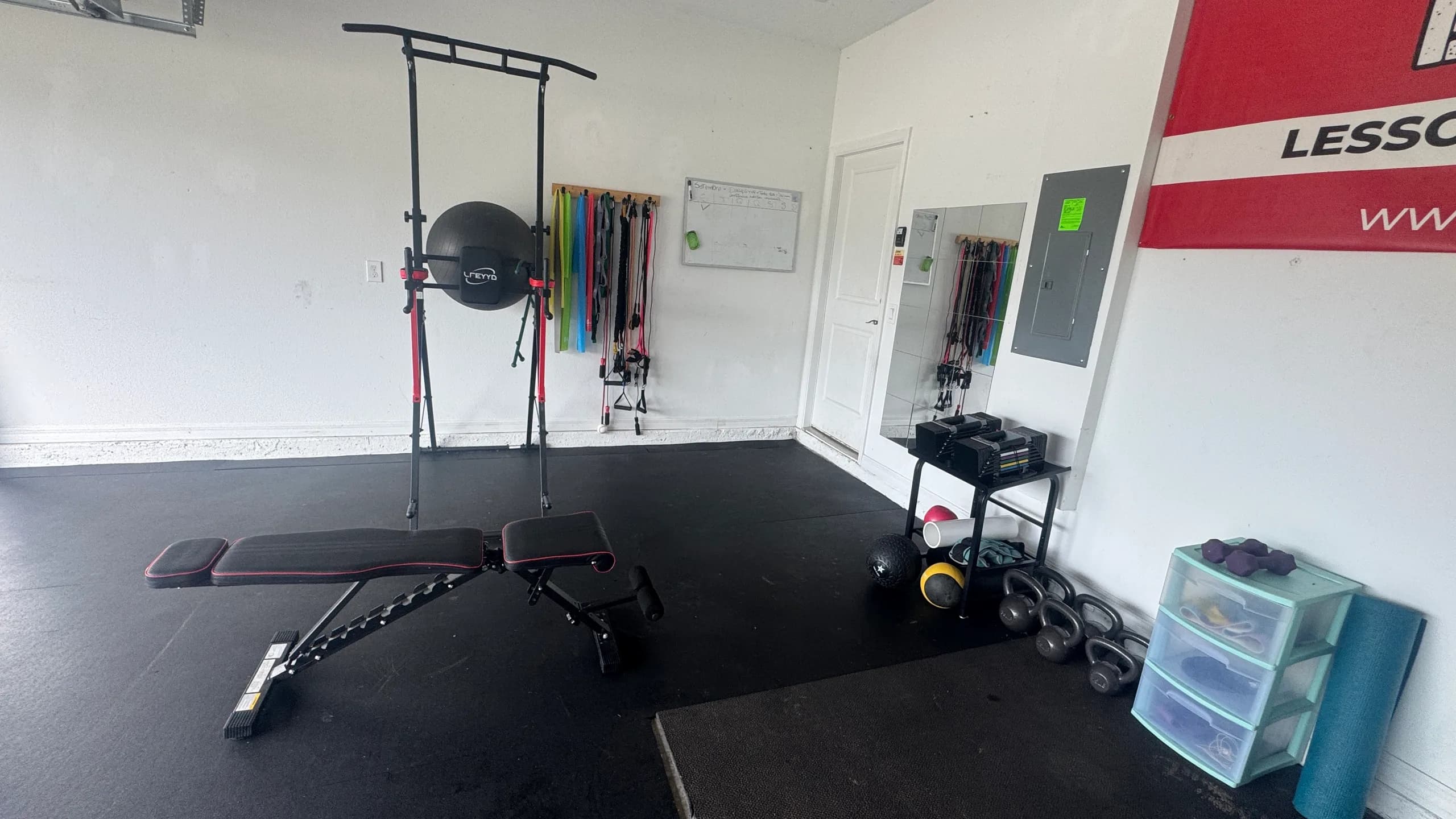 Open floor of the MADE Baseball garage with an adjustable bench and pull-up rack