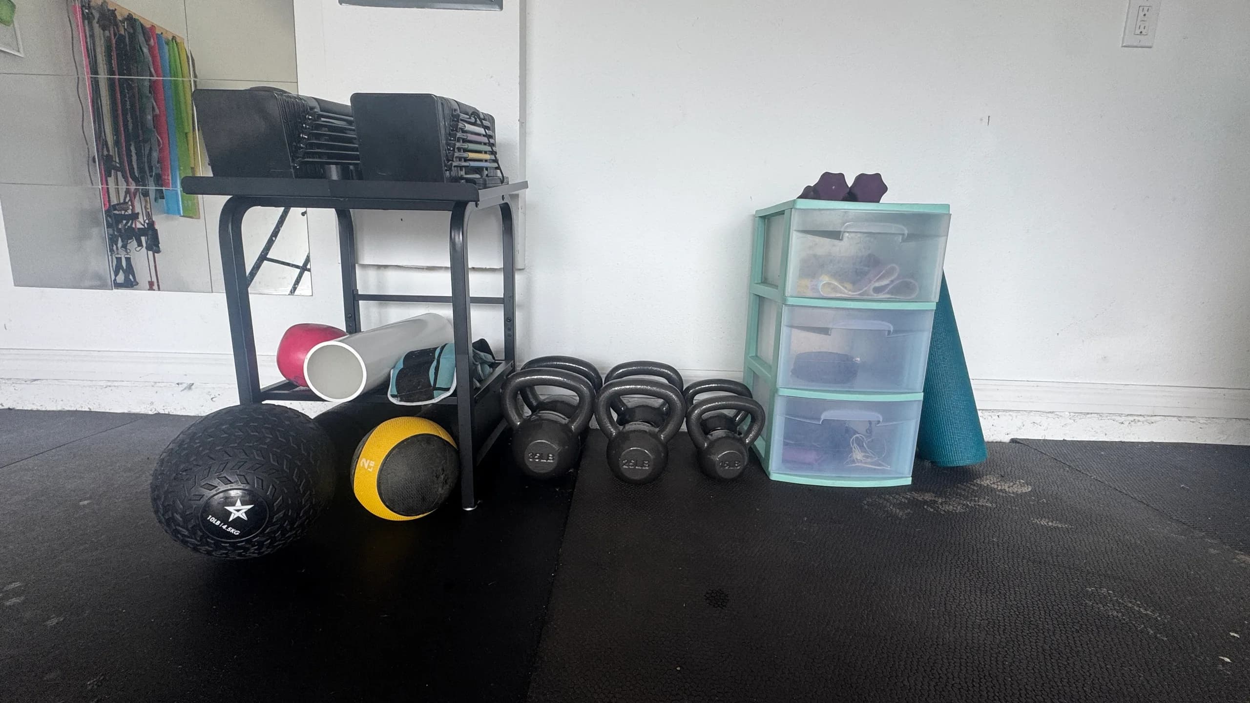 Dumbbells kettlebells medicine balls and resistance bands at the MADE Baseball garage