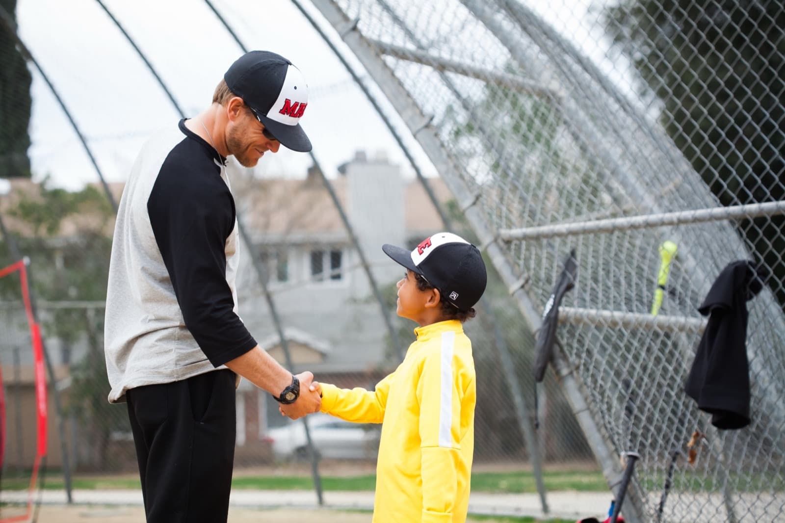 A handshake at the batting cage between a host and a player's parent